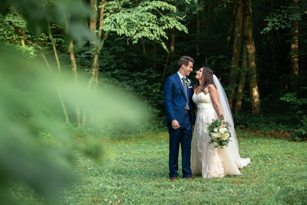 Bride and groom walking near woods in Tennessee Outdoor Farm Wedding